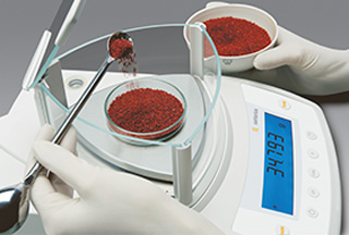 laboratory balance measuring red powder